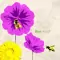 Včely na zářivých fialových a žlutých květech s nápisem "Bee kind!" vedle jedné včely, která sdílí poselství laskavosti s hravou včelí hříčkou.